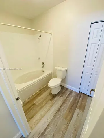 a bathroom with a white toilet and a shower