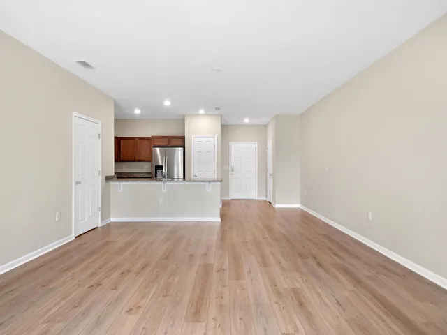 a view of kitchen with kitchen island wooden floor and living room