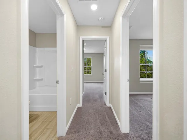 a view of a hallway with wooden floor