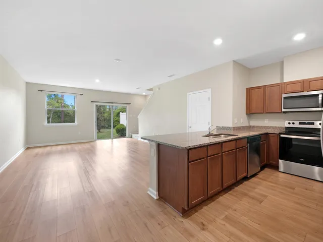 a kitchen with stainless steel appliances granite countertop a stove a sink and a refrigerator