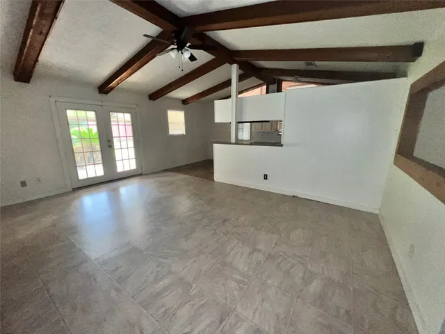 a view of a livingroom with window and wooden floor