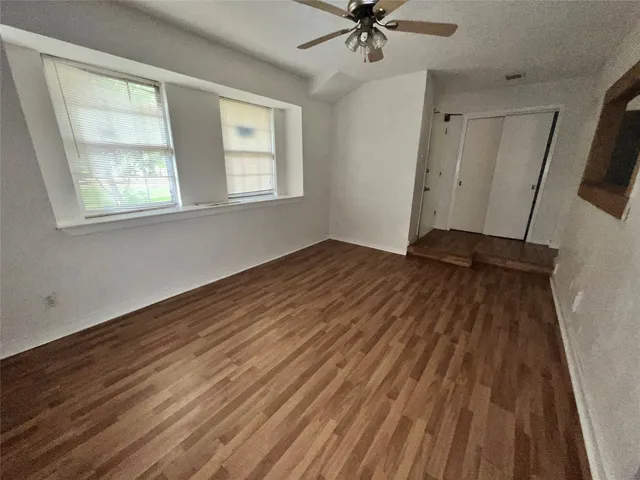 a view of a livingroom with a hardwood floor and a ceiling fan