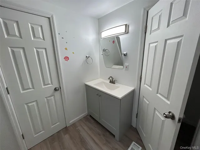 a bathroom with small sink and mirror