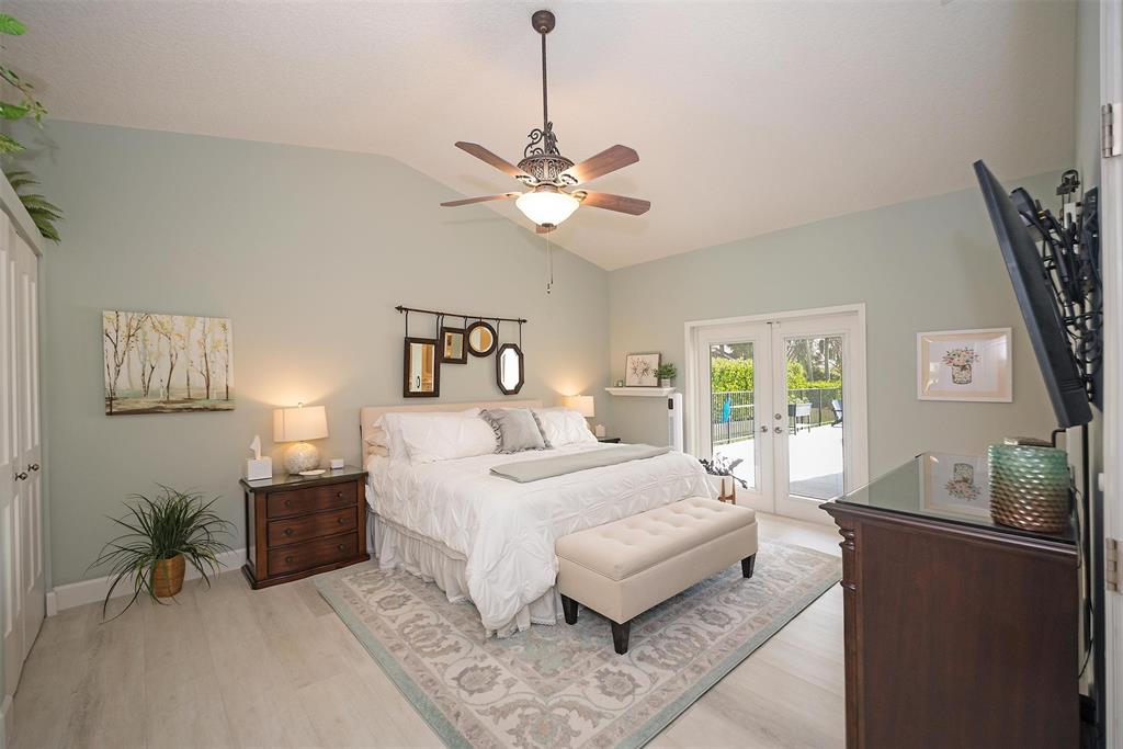 7810 Northwest 87th Avenue Tamarac, FL 33321 - Photo 12 of 21 a bedroom with a large bed and a chandelier