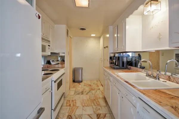 a large kitchen with stainless steel appliances granite countertop a sink stove and refrigerator
