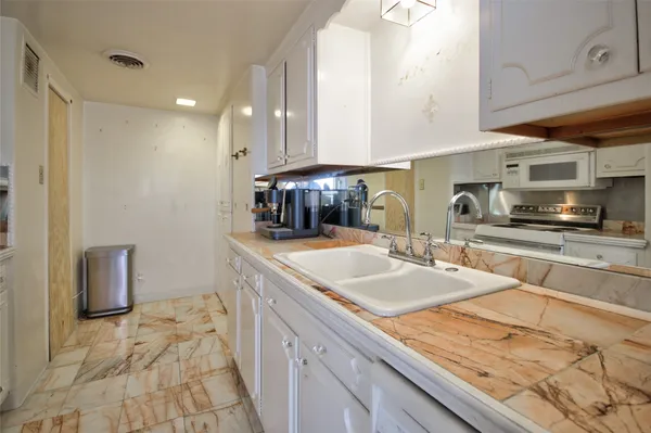 a kitchen with stainless steel appliances granite countertop a sink a stove and a refrigerator