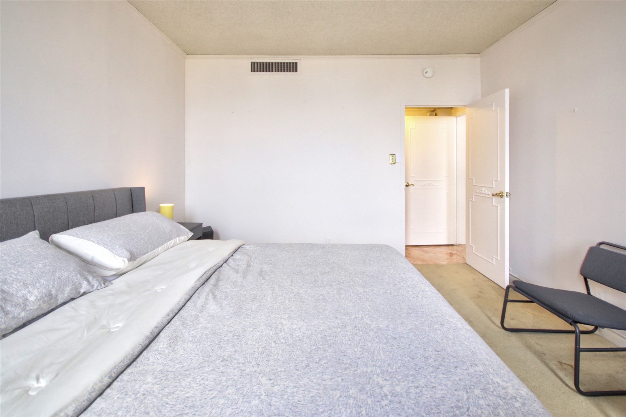 2701 Westheimer Road, Unit 7H Houston, TX 77098 - Photo 18 of 21 a bedroom with a bed and a chair