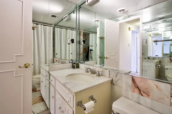 a bathroom with a double vanity sink mirror and toilet