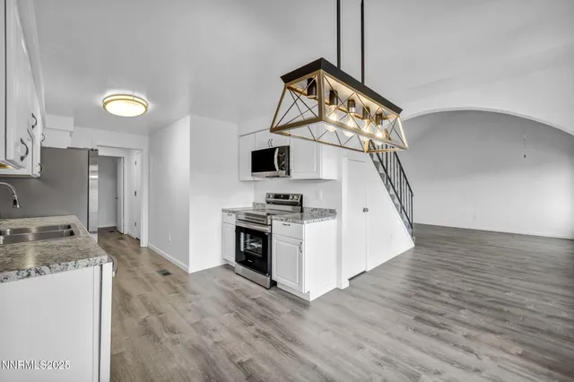 a kitchen with stainless steel appliances granite countertop white cabinets sink and a granite counter tops
