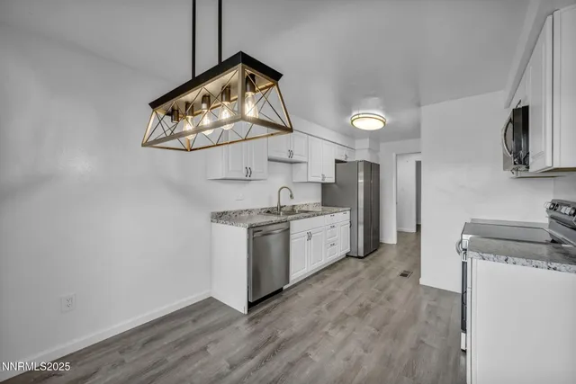 a kitchen with granite countertop a sink and steel appliances