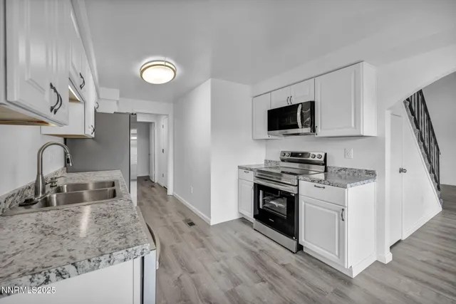 a kitchen with stainless steel appliances a stove a microwave and sink