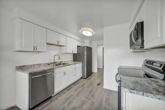 a kitchen with stainless steel appliances a refrigerator and a stove top oven