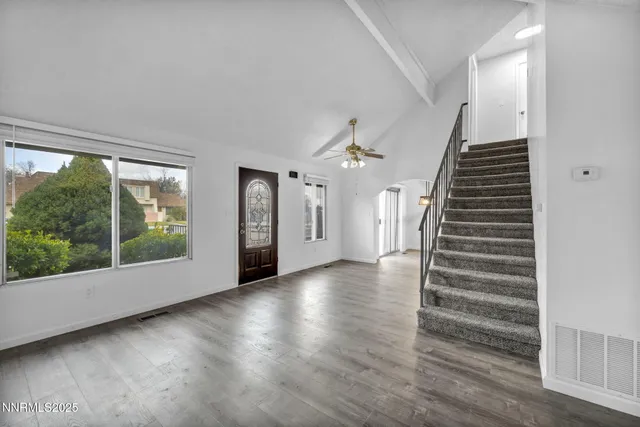 a view of a hallway with wooden floor and staircase