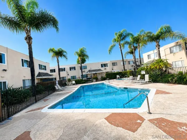 a view of swimming pool with palm trees