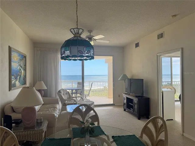 a living room with furniture a large window and a flat screen tv