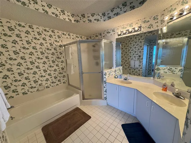 a bathroom with a bathtub sink vanity granite and a shower