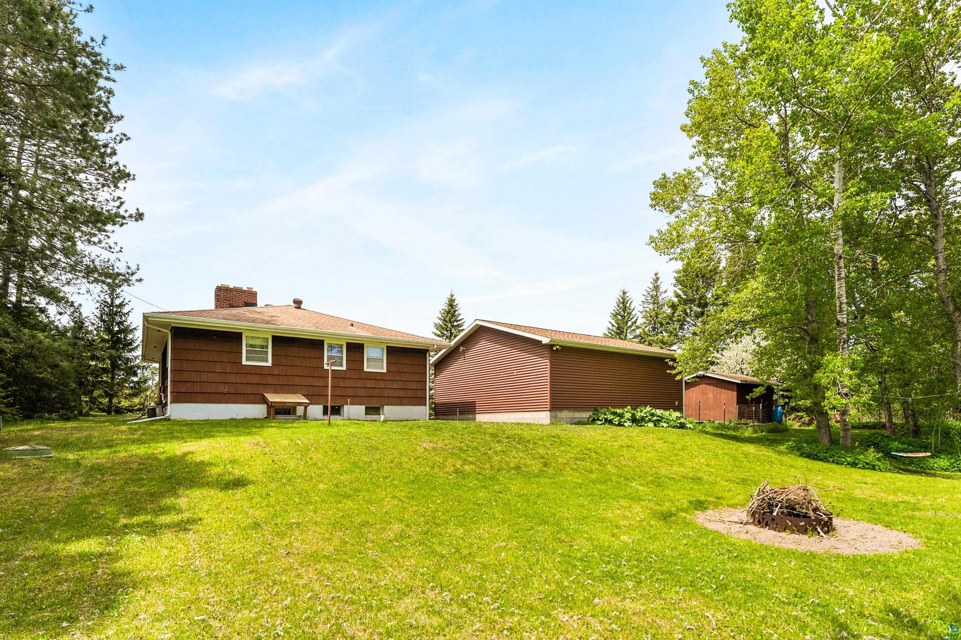 4808 Midway Road Duluth, MN 55811 - Photo 49 of 57 Expansive sloped lawn area featuring a fire pit and mature trees