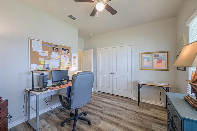 a view of a workspace with furniture and a window