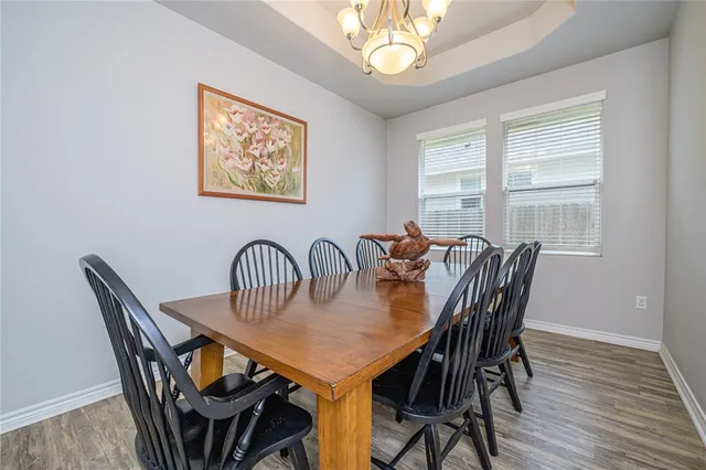a view of a a dining room with furniture window and wooden floor