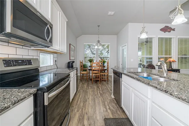 a kitchen with stainless steel appliances granite countertop a stove and a sink
