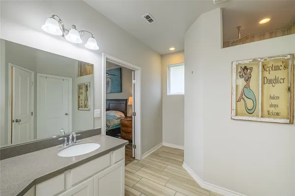 a bathroom with a granite countertop double vanity sink and a mirror