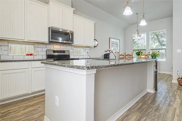 a kitchen with appliances a sink and cabinets
