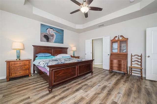 a bedroom with a bed and wooden floor