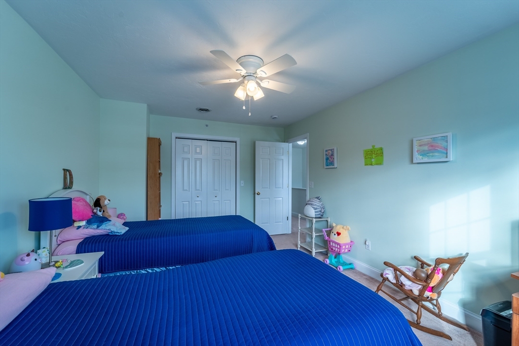 17 Village Way, Unit 17 Rutland, MA 01543 - Photo 15 of 33 a bedroom with a bed and a chandelier