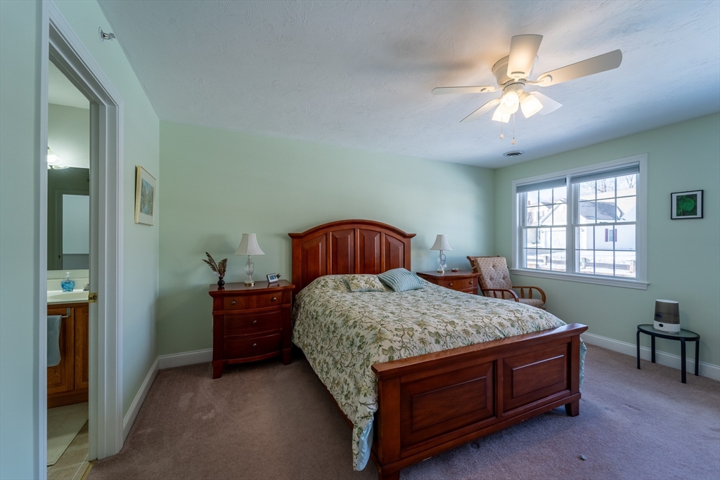 17 Village Way, Unit 17 Rutland, MA 01543 - Photo 17 of 33 a bed sitting in a room next to a window and a chandelier