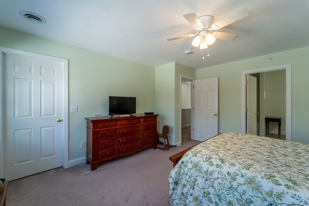 17 Village Way, Unit 17 Rutland, MA 01543 - Photo 19 of 33 a bedroom with a bed and a chandelier