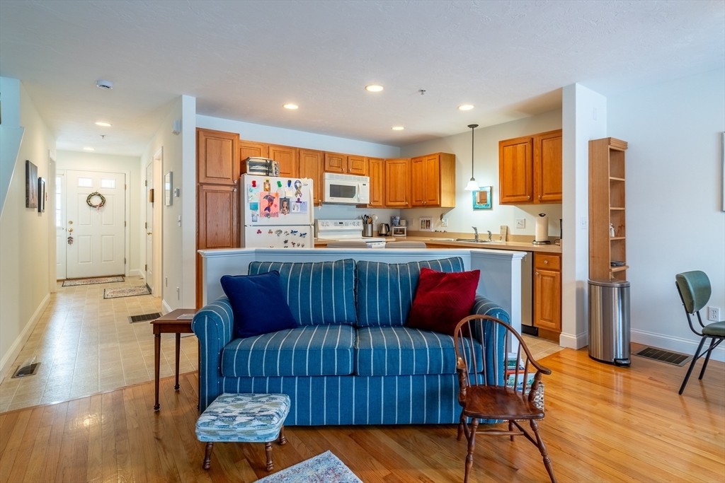 17 Village Way, Unit 17 Rutland, MA 01543 - Photo 5 of 33 a kitchen with stainless steel appliances kitchen island granite countertop wooden floor a dining table and chairs