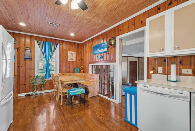 a living room with stainless steel appliances furniture fireplace and a large window