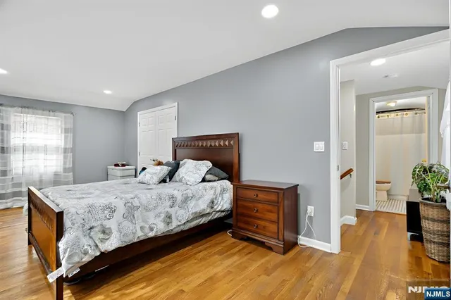 a bedroom with a bed and a potted plant on the dresser