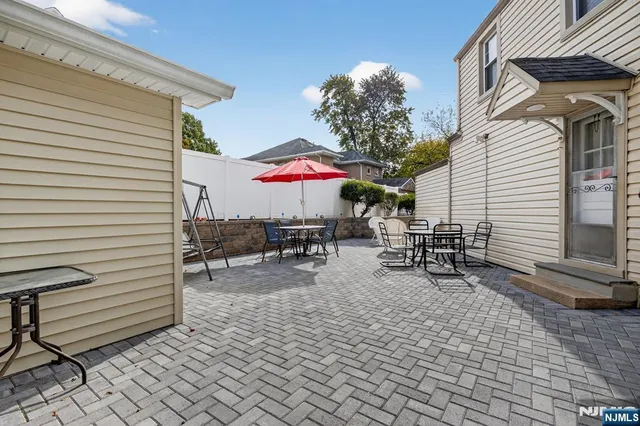 a view of a patio with a table and chairs under an umbrella