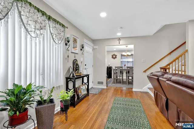 a hallway with a flower pot and a dining table with wooden floor