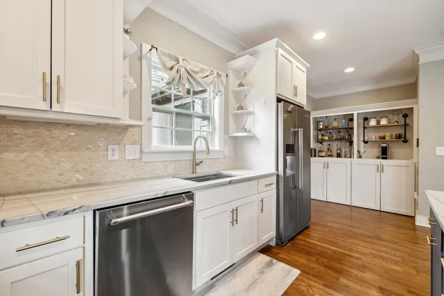 a kitchen with granite countertop white cabinets and white appliances
