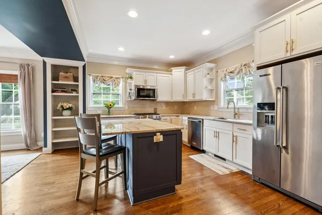 a kitchen with kitchen island granite countertop wooden floors and stainless steel appliances