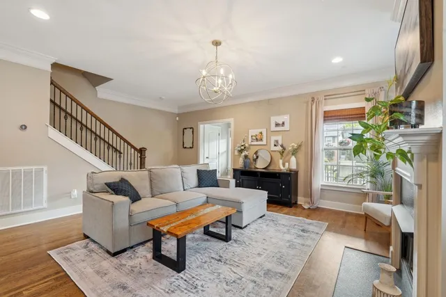 a living room with furniture a fireplace and a chandelier