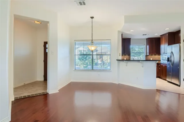 a view of a kitchen with wooden floor and a window