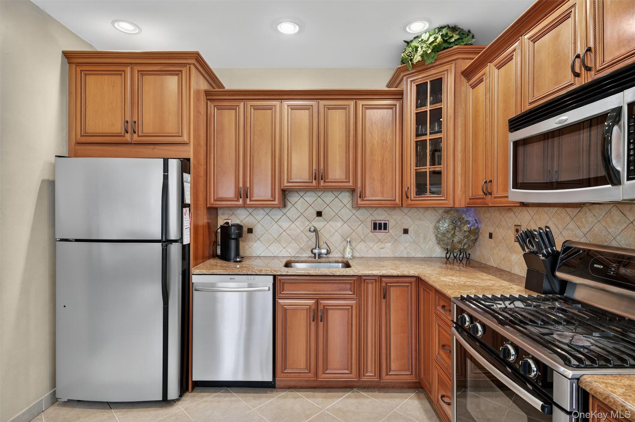 449 West Mombasha Road Monroe, NY 10950 - Photo 8 of 39 a kitchen with stainless steel appliances granite countertop a stove top oven a refrigerator a sink and dishwasher with wooden cabinets
