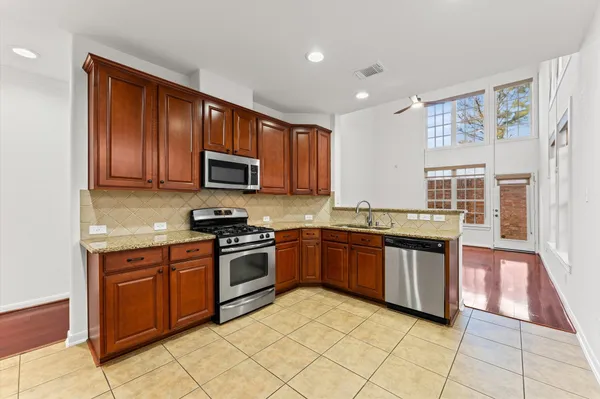 a kitchen with stainless steel appliances granite countertop wooden cabinets a stove top oven a sink and dishwasher