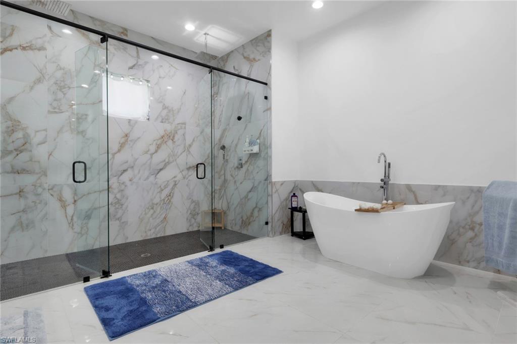 491 9th Street Southwest Naples, FL 34117 - Photo 17 of 49 a bathroom with a bathtub a toilet a sink and shower