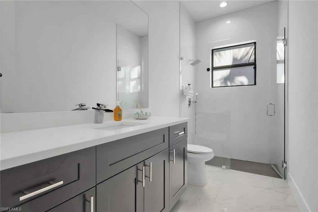 491 9th Street Southwest Naples, FL 34117 - Photo 19 of 49 a bathroom with a sink a toilet and mirror