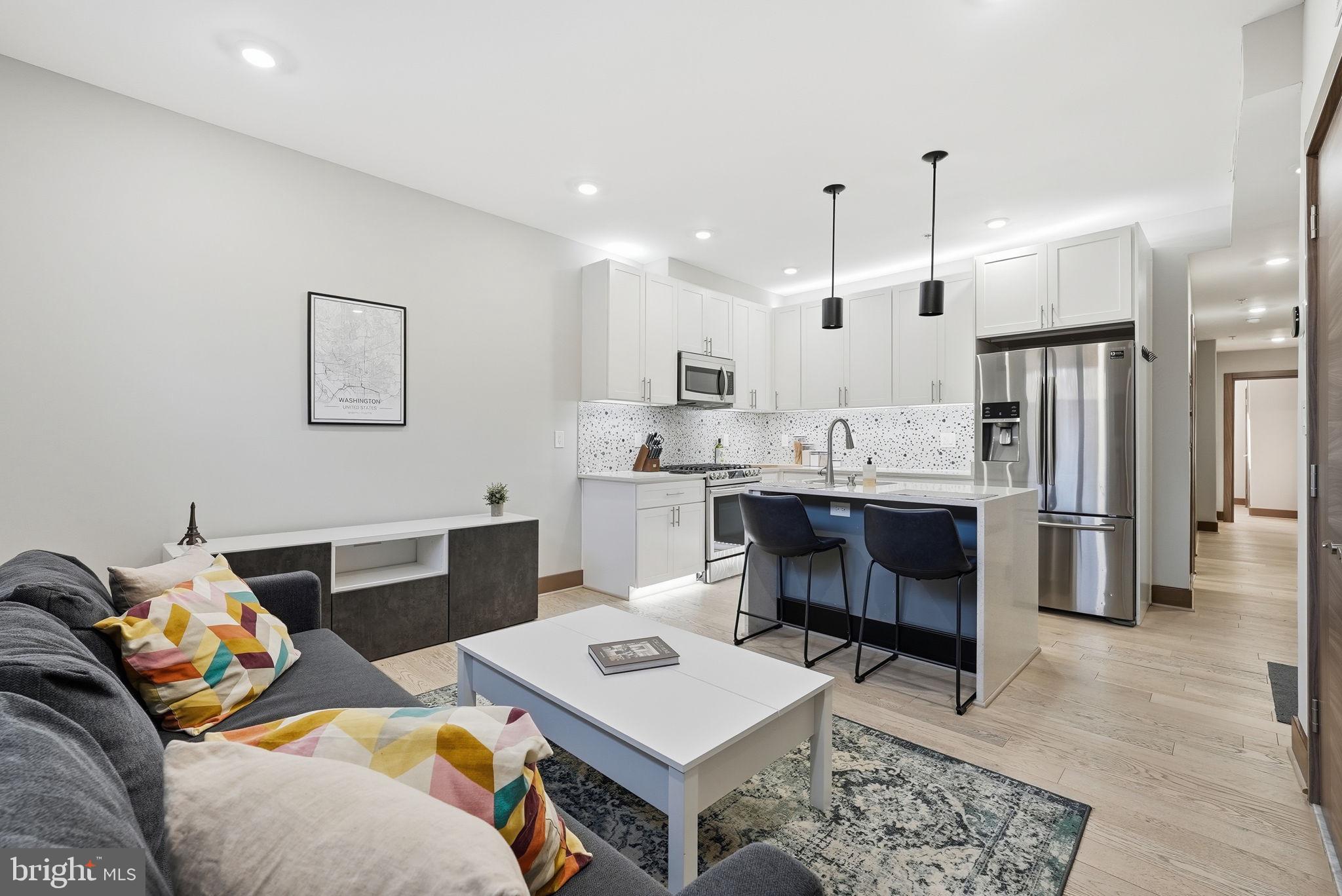 2109 M Street Northeast, Unit 5 Washington, DC 20002 - Photo 2 of 11 a living room with furniture a flat screen tv and kitchen view