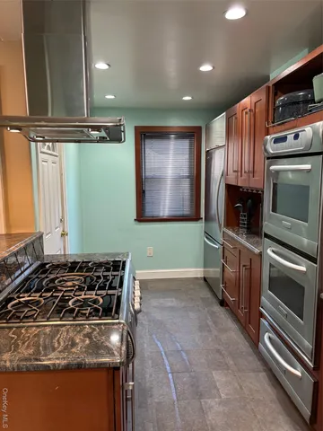 a kitchen with wooden cabinets and a stove top oven