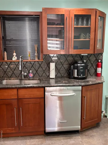 a kitchen with stainless steel appliances granite countertop wooden cabinets a stove and a sink