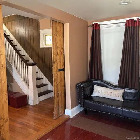 a view of a hallway with wooden floor and staircase