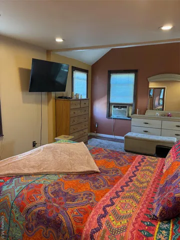 a bedroom with a large bed and a flat screen tv