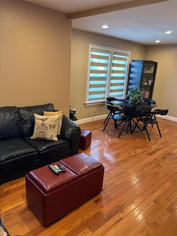 a living room with furniture a wooden floor and a large window
