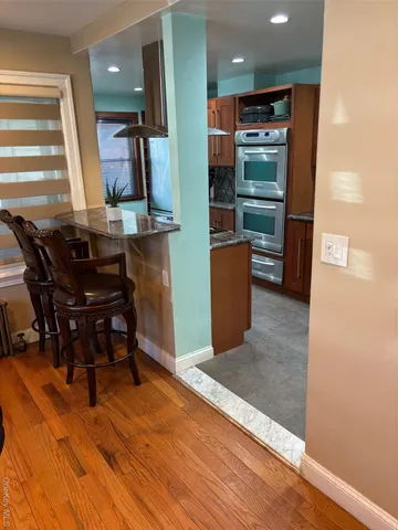 a kitchen with stainless steel appliances wooden cabinets dining table and chairs
